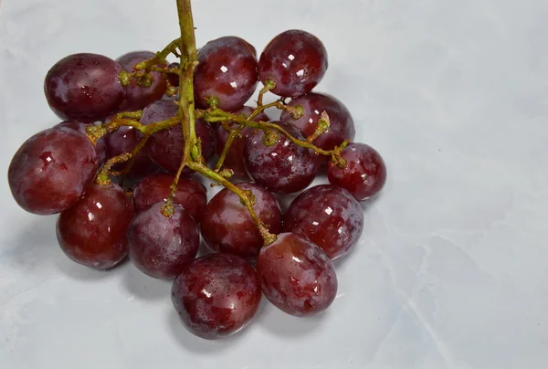 Uva rossa su mattonelle bianche — Foto Stock