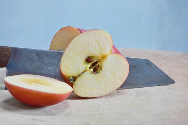 Knife slice apple on wooden chop plate — Stock Photo, Image