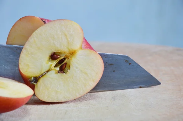 Knife slice apple on wooden chop block — Stock Photo, Image