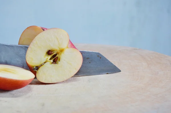 Couteau coupé pomme rouge sur bloc de côtelette — Photo