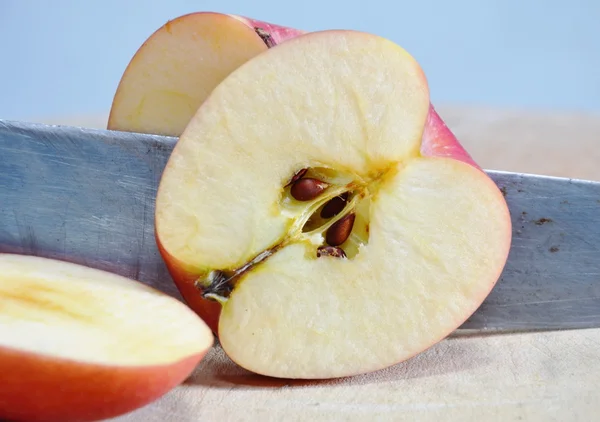 Knife slice red apple on chop block — Stock Photo, Image