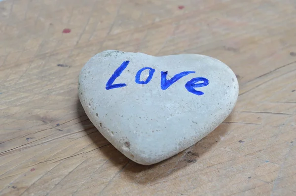 Камінь у формі серця на дерев'яному фоні — стокове фото