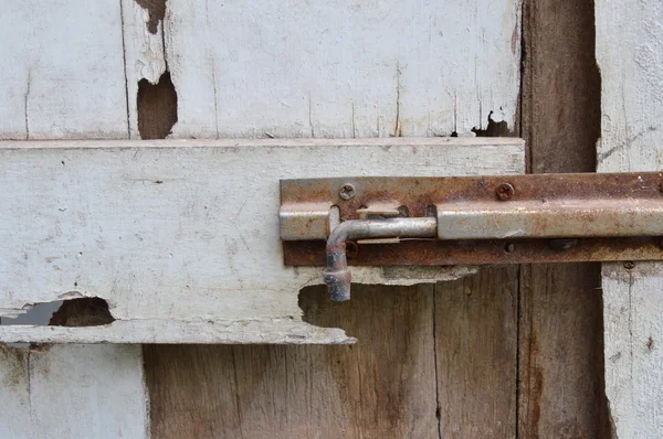 Bullone arrugginito sulla porta di legno bianco decadimento — Foto Stock