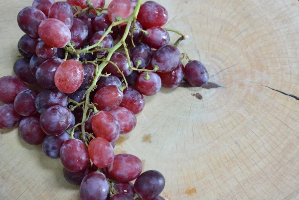Червоний виноград на дерев'яному подрібненому блоці — стокове фото