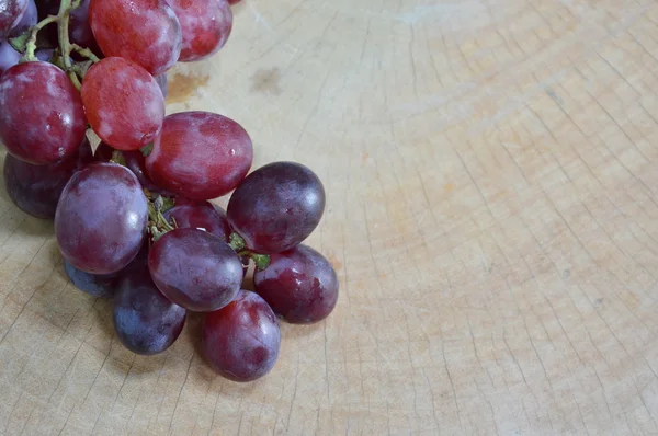 Raisin sur bloc de coupe en bois — Photo