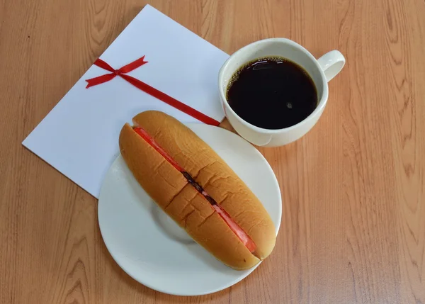 Pan de perro caliente relleno de fresa crema pasas y café negro — Foto de Stock