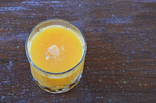 Glas Orangensaft auf Holztisch — Stockfoto
