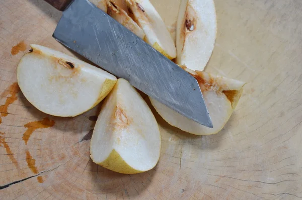 Poire chinoise coupée au couteau sur plaque à découper en bois — Photo