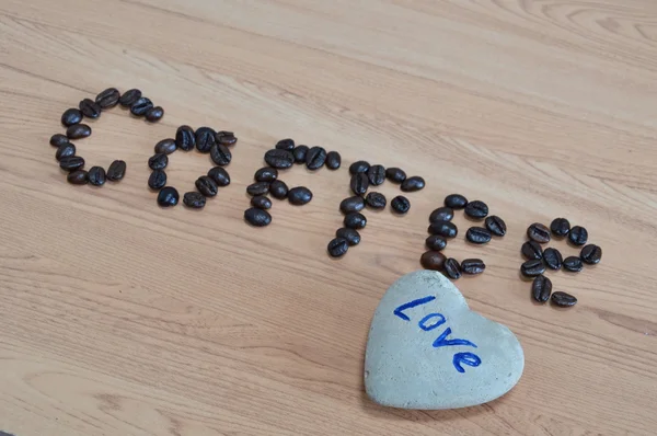 Heart stone and coffee seed — Stock Photo, Image