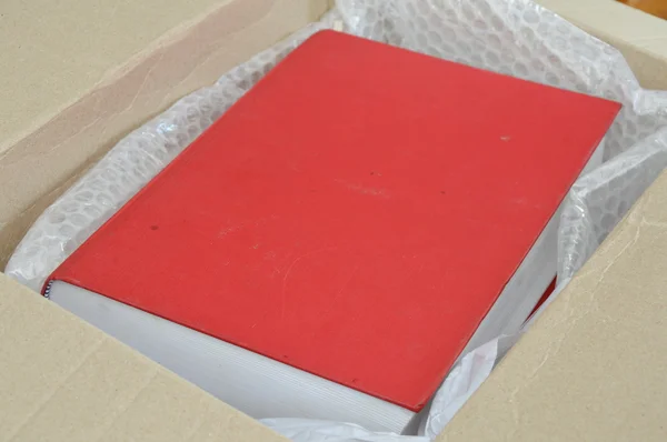 Libro rojo en caja de papel marrón —  Fotos de Stock