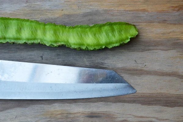 Ala frijol y cuchillo de cocina sobre tabla de madera — Foto de Stock