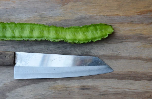 Ala frijol y cuchillo de cocina sobre tabla de madera — Foto de Stock