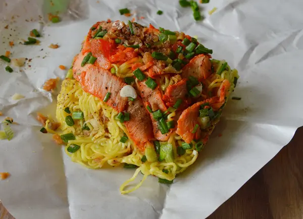 Fideos de huevo rematando carne de cerdo barbacoa en paquete de papel para llevar a casa — Foto de Stock