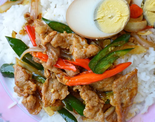 Aduk babi goreng dengan cabe panjang manis dan topping setengah telur rebus pada beras — Stok Foto