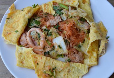 Kızarmış sukiyaki çanak üzerinde yumurta sarılı deniz ürünleri ile karıştırın