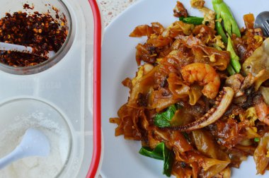 siyah soya sosu ve baharat kutusu deniz ürünleri ile tavada kızartılmış erişte