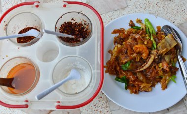 siyah soya sosu ve baharat kutusu deniz ürünleri ile tavada kızartılmış erişte