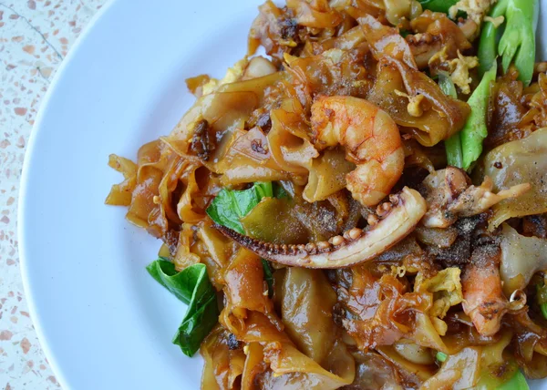 Stir-fried noodle with seafood in black soy sauce — Stock Photo, Image