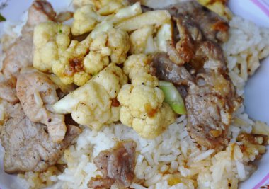 sade pilav üzerinde marine edilmiş domuz eti ile tavada kızartılmış karnabahar