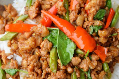 biber ve fesleğen soslu tavada kızartılmış kıyılmış domuz eti pirinç üzerine bırakır