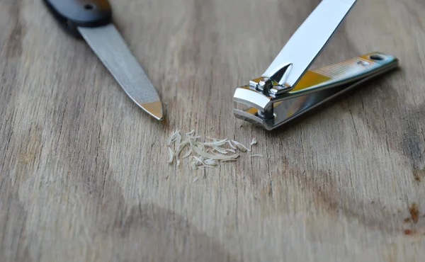 Tondeuse et lime à ongles sur planche en bois — Photo