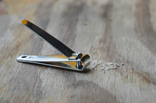 Coupe-ongles et ferraille sur planche en bois — Photo