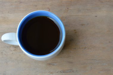 Siyah kahve fincanı ahşap masada.