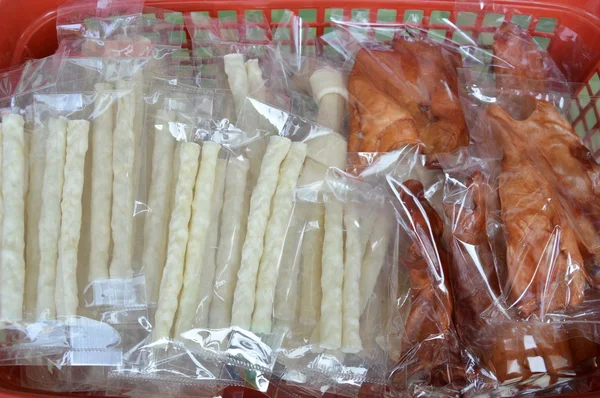 dog snack in plastic bag packing on basket for sale in pet shop