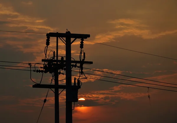 Poste eléctrico de alto voltaje en la puesta del sol — Foto de Stock
