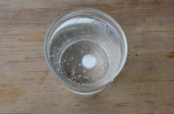 Antiácidos en vaso de agua sobre mesa de madera —  Fotos de Stock