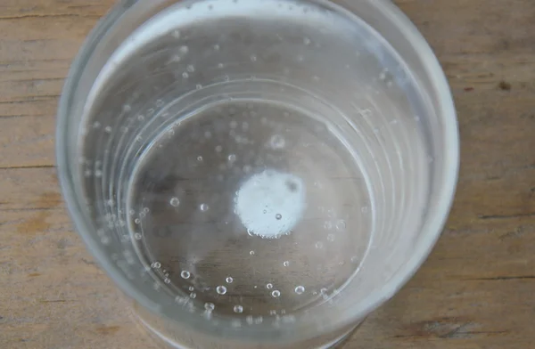 Антациди у водяному склі на дерев'яному столі — стокове фото