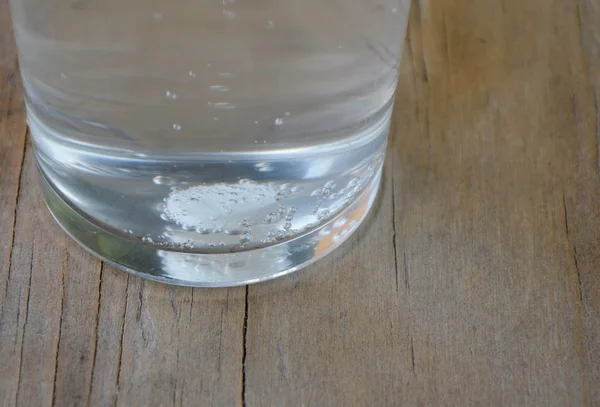 Antiácidos en vaso de agua sobre mesa de madera — Foto de Stock