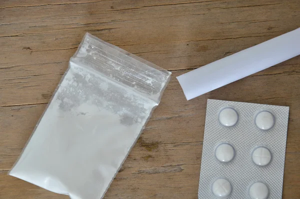 Кокаин в закрывающемся пакете и пузырь от наркотиков с бумагами — стоковое фото
