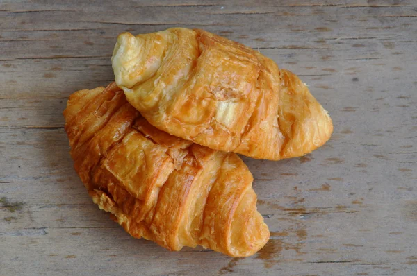 Croissant manteiga em tábua de madeira — Fotografia de Stock