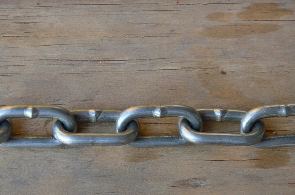 Železný řetěz na dřevěné desce — Stock fotografie