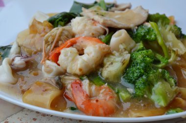 tavada kızartılmış büyük noodle ile deniz ürünleri sos sos yemeğin üzerinde