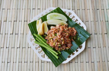 taze muz yaprağı üzerinde ot ile baharatlı salata karides