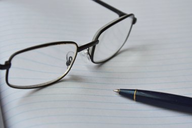 gözlük camı ve kalem kitap