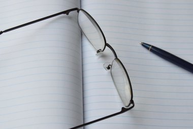 gözlük camı ve kalem kitap