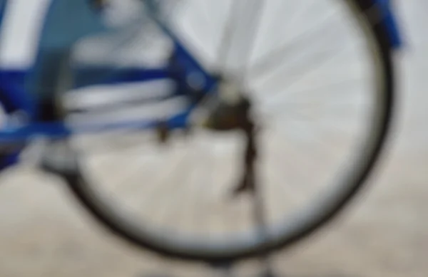 Sfocata bicicletta parcheggio ruota sulla strada in giornata di sole — Foto Stock