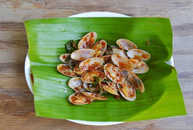 kavrulmuş chili Yapıştır ile kızarmış istiridye taze muz yaprağı ilave edin.