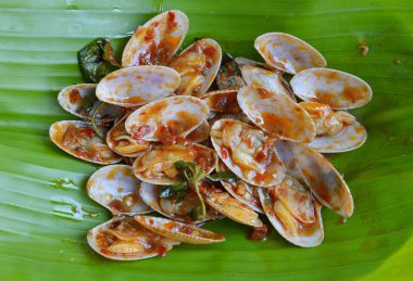 kavrulmuş chili Yapıştır ile kızarmış istiridye taze muz yaprağı ilave edin.