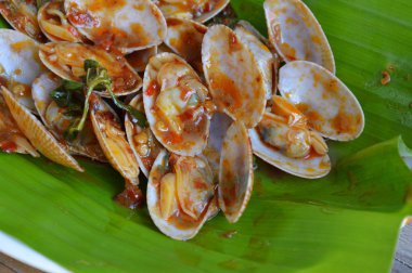 kavrulmuş chili Yapıştır ile kızarmış istiridye taze muz yaprağı ilave edin.