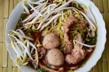 Çin noodle ile domuz topu kabı üzerindeki kahverengi çorbası