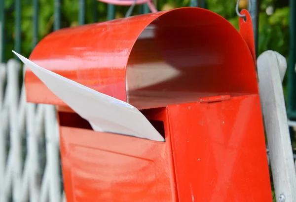 Ev çit üzerinde kırmızı posta kutusuna mektup — Stok fotoğraf