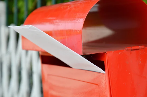 Letter in red post box on home fence — Stock Photo, Image