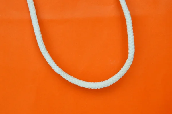 Saco de papel laranja e punho de nylon branco — Fotografia de Stock