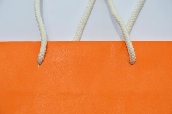 Sacchetto di carta arancione e manico in nylon bianco — Foto Stock