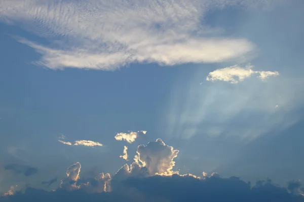 La lumière du soleil se répand derrière les nuages sur le ciel — Photo