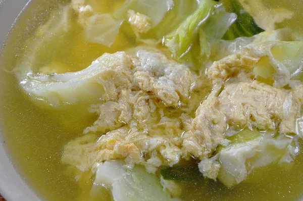 Boiled egg with cabbage in hot soup on bowl — Stock Photo, Image